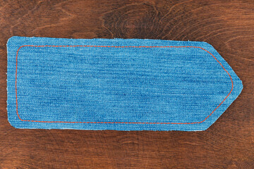 Pointer made from denim lying on a wooden surface.