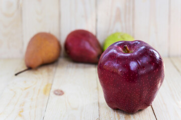 single red apple with pear on wooden background