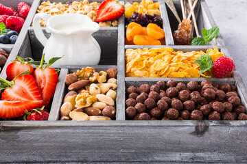 Old gray wooden box with variety of cold quick breakfast cereals and berries for breakfast, healthy eating concept, selective focus.