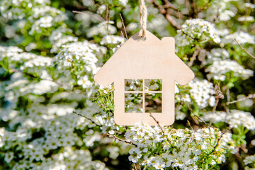 The symbol of the house hangs among the flowering branches of Spirea 