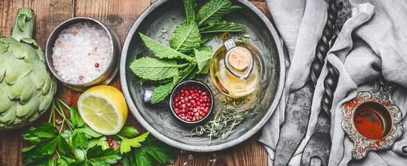 Fresh condiment and seasoning setting on rustic kitchen table background, top view, banner