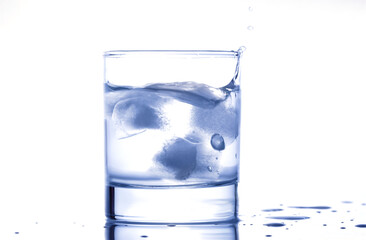 blue water splashing out of a glass with drops