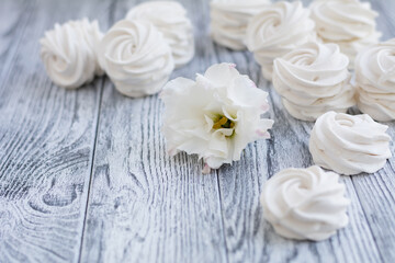 White zephyr and white flower on grey wooden background