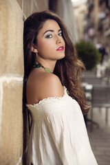 Fototapeta premium beautiful girl with long hair cast on a wall looking at the camera