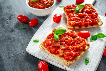 Fresh homemade crispy Italian appetizer Bruschetta topped with tomato, eggplant, Zucchini, Yellow pepper, garlic and basil on white wooden board. healthy food
