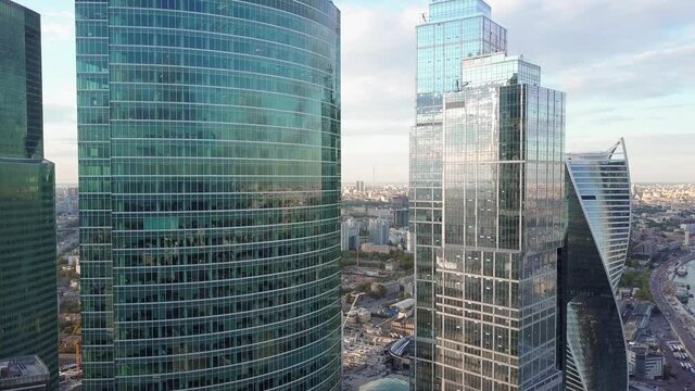 Aerial rising shot of reflective office skyscraper details in a modern business district. 4K video