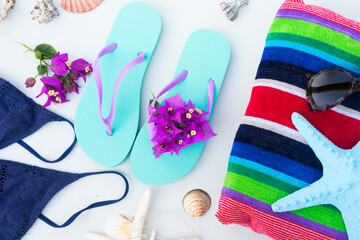 Summer beach fun - sandals with swimming suit, beach towel and starfish