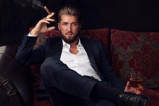 Erfolgreicher Gesch&auml;ftsmann entspannt bei Zigarre und Wein
