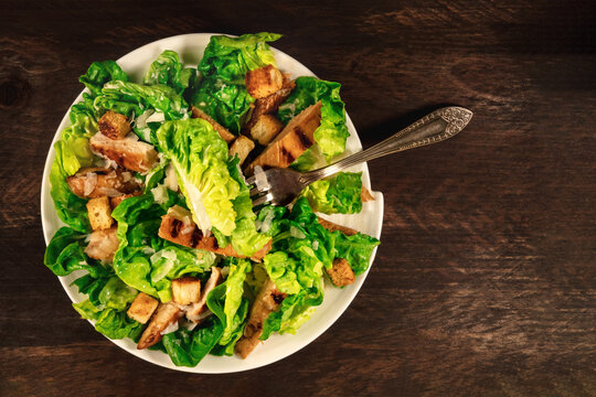 Chicken Caesar salad on rustic background with copyspace