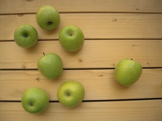 Green sweet apples on the wooden table