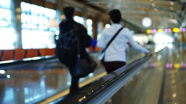 4k Ultra hd shot of travalator in airport madrid. People with luggage move by it. Big depth of field blurred background view. No faces. TRipod shot