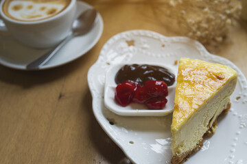 Cheese cake with hot coffee cup on wooden table