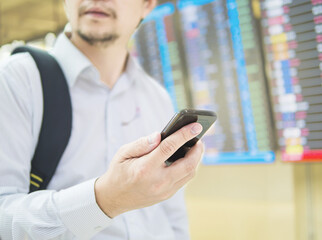 Business traveler using mobile phone during his journey at airport terminal
