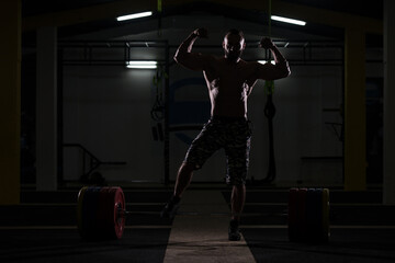 Obraz na płótnie Canvas Silhouette Bodybuilder Flexing Muscles