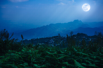 Obraz premium Night sky with cloudy and sunbeam, foggy is swingin above mountain peak.