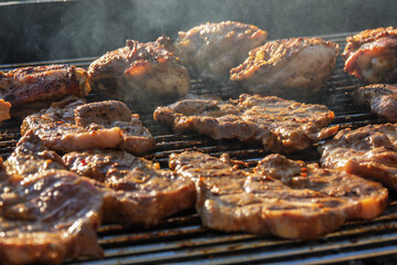 barbecueing on beautifull sunny day. steaks, chicken legs close-up