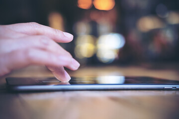 A hand pointing , touching and using tablet with blur background in cafe