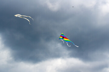 Flying kite on the cloudy blue sky background