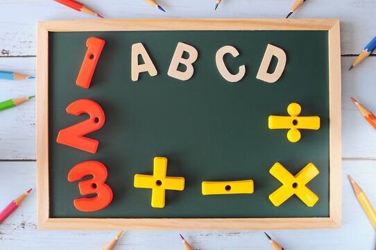 Alphabet letters and number with math symbol on blackboard with colored pencil, education concept and back to school idea.
