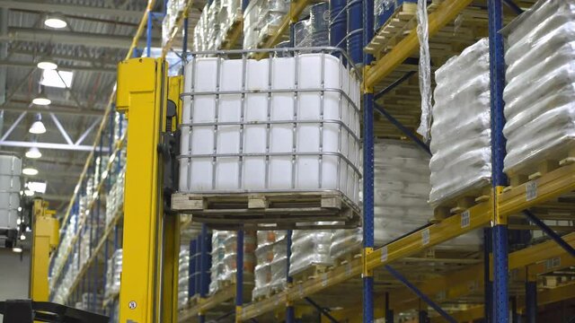 Loader operator on stackers take cargo from the rack in the warehouse