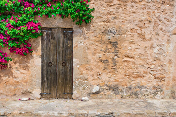 Dorf Haus Mediterran Rustikal mit Holz Tür, Stein Mauer und Bougainvillea