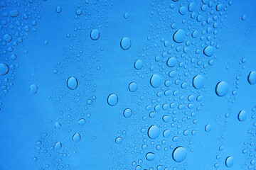 raindrop on window glass against blue sky