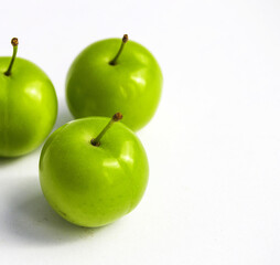 Sour plum pictures on white ground, wonderful sour plums, green plums pictures from the first fruits in summer
