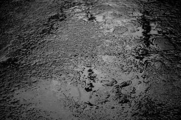 abstract texture background rain drops rippling in a puddle with blue sky reflection