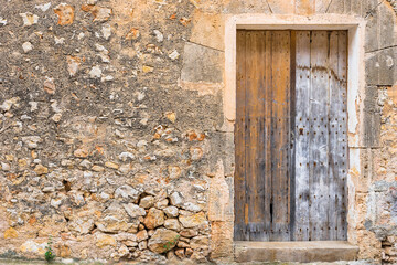 Fototapeta na wymiar Shabby wooden front door and stone wall background