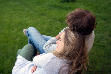 Obraz premium Young people, a woman and a man head to head, relax in the garden