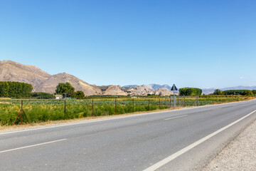 View of a long road with a landscape and a blue sky in the background