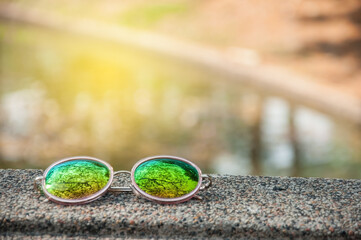 Cycle lens sun glasses in park with light flare.