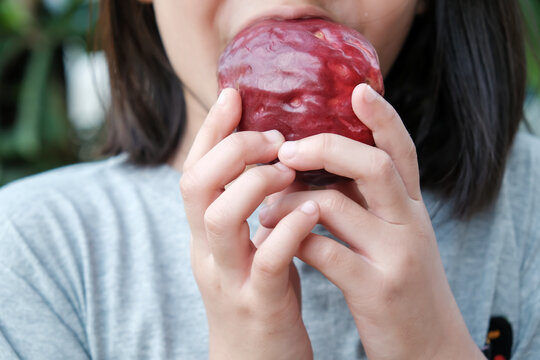 Girl eating Malay Apple (Pomerac)