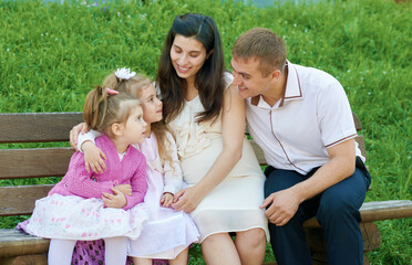 Fototapeta premium happy family in summer city park outdoor, pregnant woman, parent and children, bright sunny day and green grass, beautiful people portrait