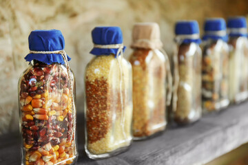 Beautiful jars with grains, cereals, legumes and seeds on wooden background