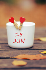 June 15th. Day 15 of month, color calendar on morning coffee cup at nature background. Summer...
