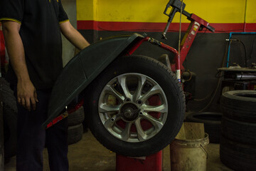 A process balance of new tire replacement at service station, mechanic changing a wheel and tires