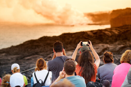 Tourists taking photos at Kalapana lava viewing area. Lava pouring into the ocean creating a huge poisonous plume of smoke at Hawaii's Kilauea Volcano, Big Island of Hawaii
