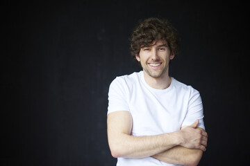 Trust me. Studio portrait of a confident young man looking honestly while standing against a black bacgkround.