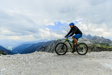 Fototapeta premium View of cyclist riding mountain bike on trail in Dolomites,Tre Cime di Laverado, South Tirol, Italy