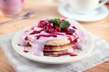 Tasty pancakes with yogurt and berries on table