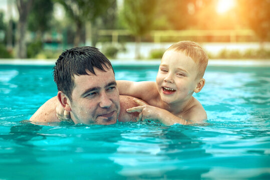 Father and son funny in  water pool under sun light at summer da