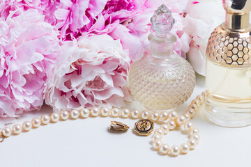 Wedding lifestyle with fresh peony flowers, glamour bottles and jewellery close up