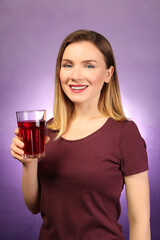 Beautiful woman with glass of fresh juice on color background