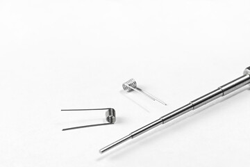 A simple Clapton coil two pieces and Micro Coil Jig on a white background isolated