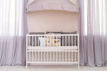 Obraz na płótnie Canvas Crib with canopy near windows in baby room