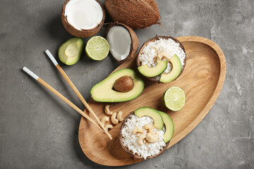 Tasty coconut rice with avocado and cashew nuts on wooden board