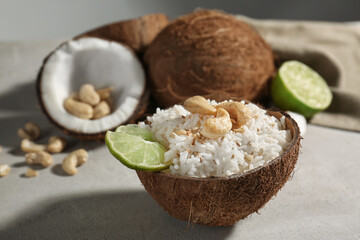 Tasty rice in coconut shell on table