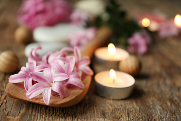 Fototapeta na wymiar Beautiful spa composition with flowers and candles on wooden background