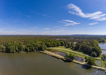 Fototapeta premium Aerial view of a small lake in the district of Buechenbach of the city of Erlangen